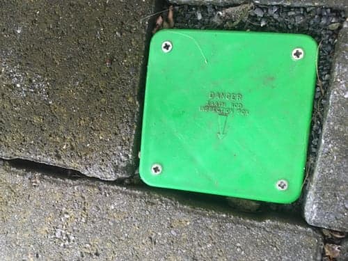 Green earth rod inspection box flush in concrete